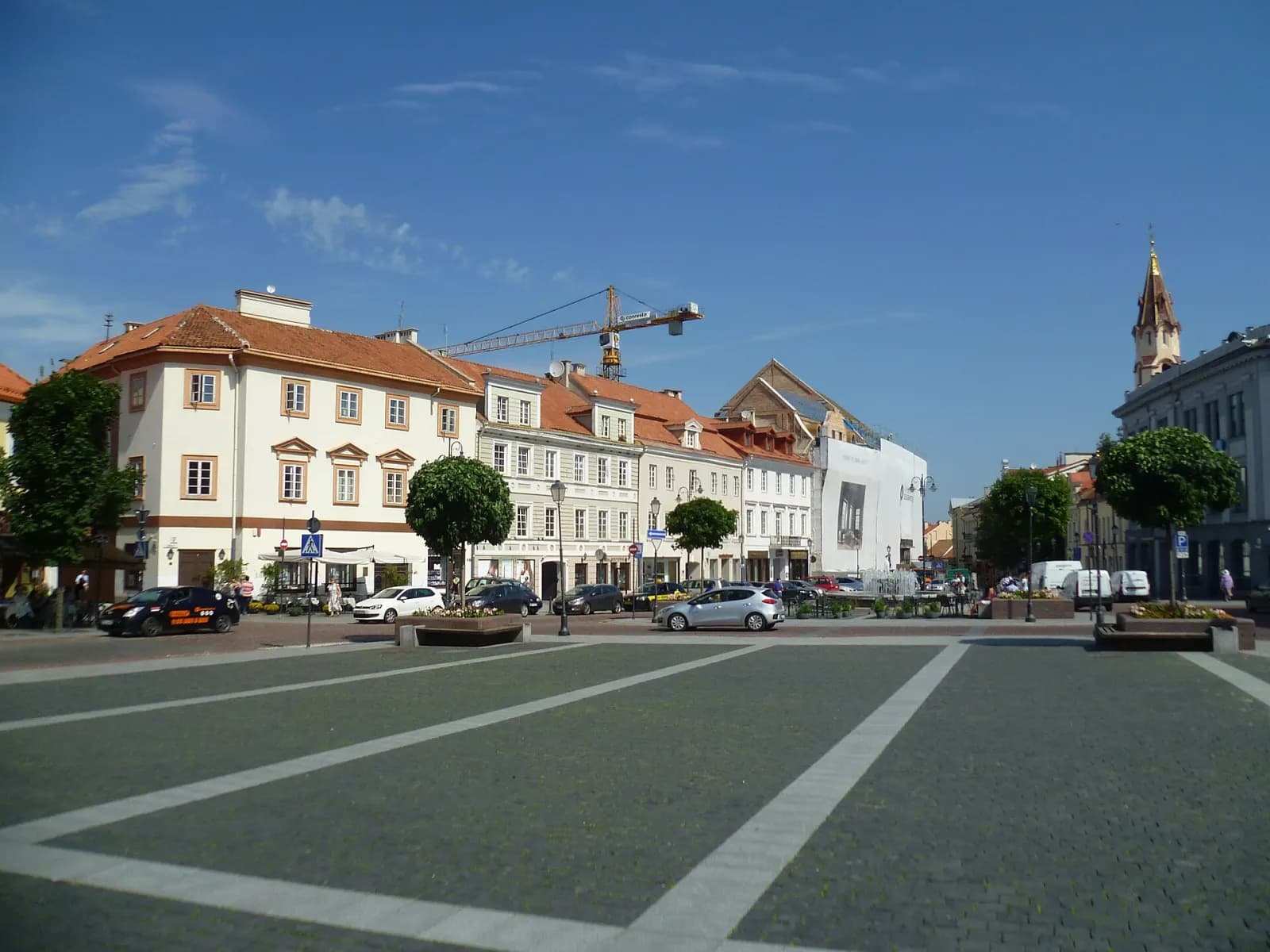 Rotušės aikštė Vilniuje su klasicistiniais pastatais ir plačia aikšte per vidurį