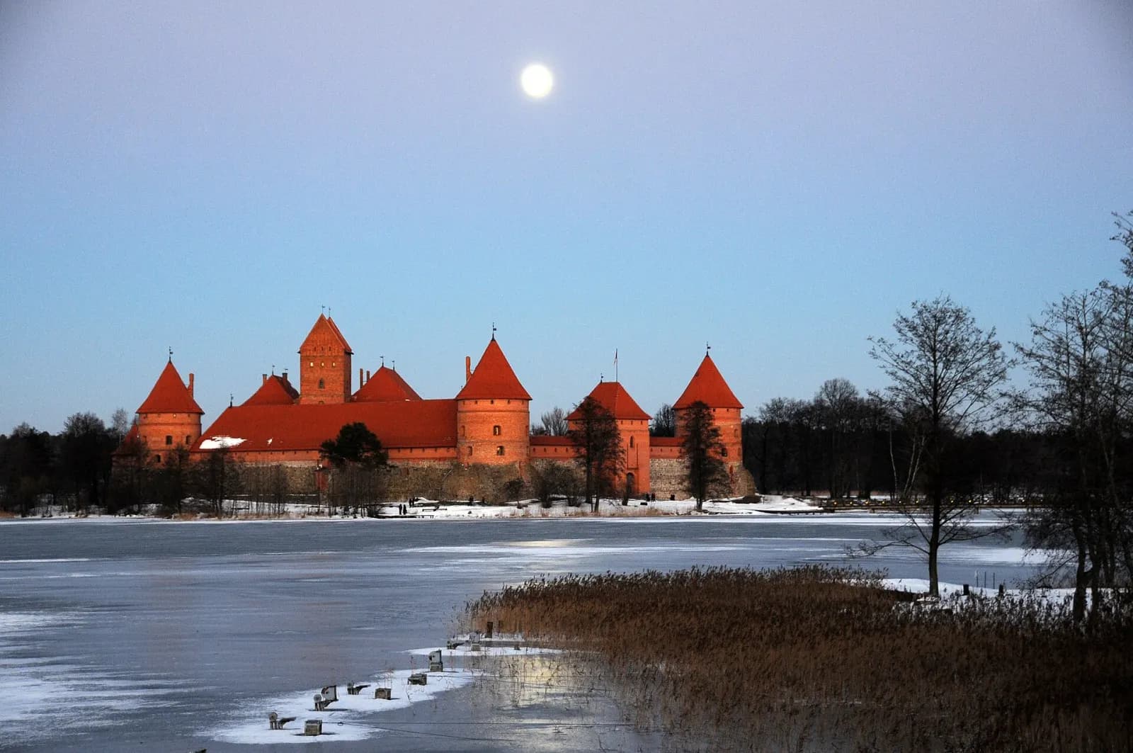 Trakų salos pilis žiemą, apsnigta pilis ant ežero kranto